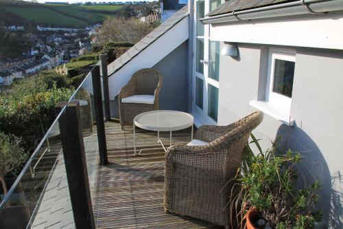 a balcony with two chairs and a table on a house at Compass Rose in Dartmouth
