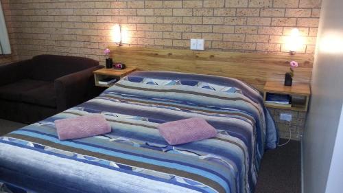 a bedroom with a bed with two pillows on it at Three Ways Motel in Gilgandra