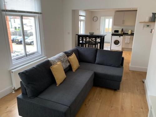 a living room with a blue couch with yellow pillows at 1 Bed Flat Sleeps 4 Free Parking Balcony in Whitstable
