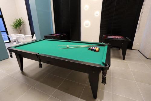a pool table with two cuesticks on top of it at Astron Suítes Mondial Salvador by Nobile in Salvador