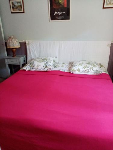 - un lit avec une couverture rose et des oreillers dans l'établissement La Jaubertie, à Meyrals
