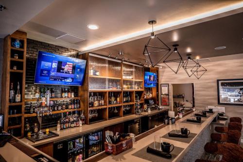 a bar with a television on a wall at Hotel Indigo Harrisburg - Hershey by IHG in Harrisburg