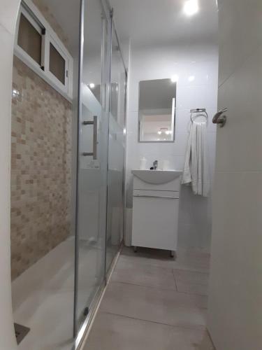 a white bathroom with a sink and a shower at Jupiter Apartments Sea View in Benalmádena