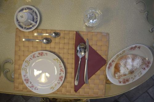 a table with two plates and a spoon and fork at Villa Felice in Giardini Naxos