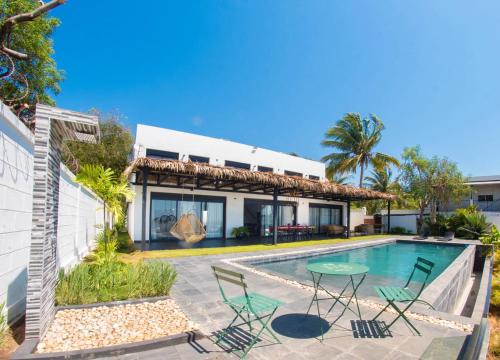 a villa with a swimming pool and a house at Villa Ilo Majunga in Mahajanga