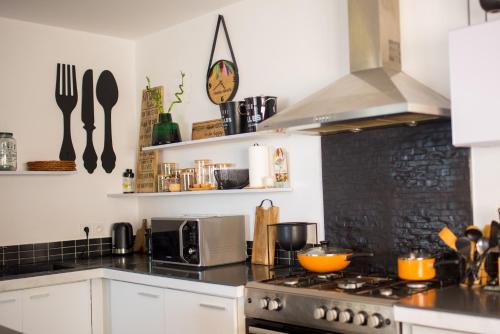 a kitchen with white cabinets and a stove top oven at Villa Ilo Majunga in Mahajanga