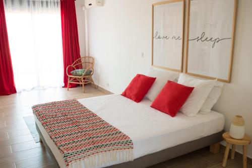 a bedroom with a bed with two red pillows at Villa Ilo Majunga in Mahajanga