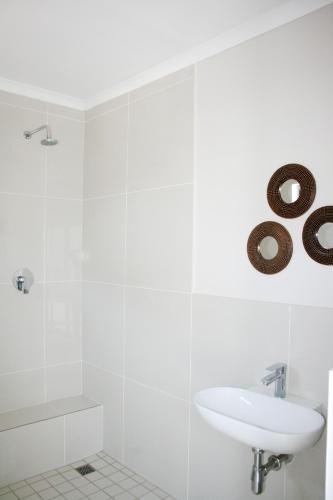 a white bathroom with a sink and a sign on the wall at Summit Place in East London