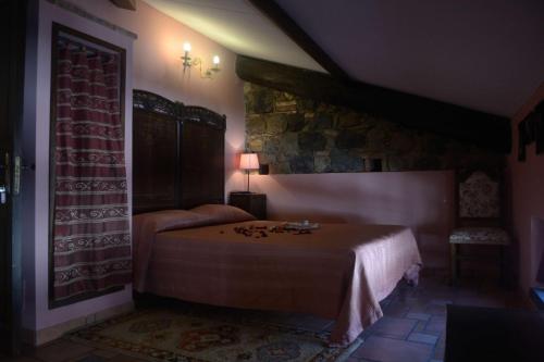 a bedroom with a bed and a stone wall at Villa Felice in Giardini Naxos
