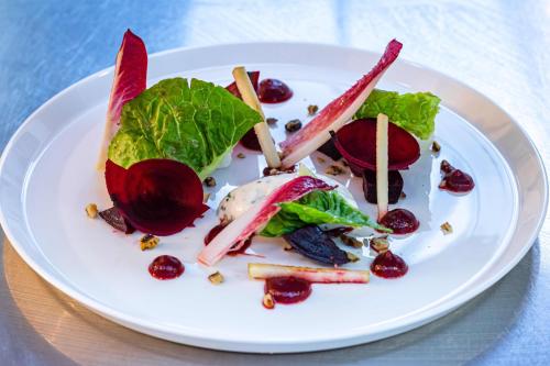 a white plate with a salad on a table at Ockenden Manor Hotel & Spa in Cuckfield