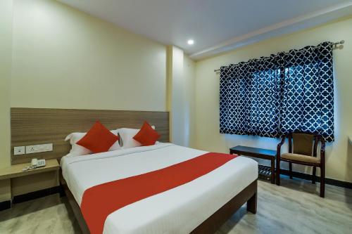 a bedroom with a bed and a desk and a window at THE ELITE INN in Visakhapatnam