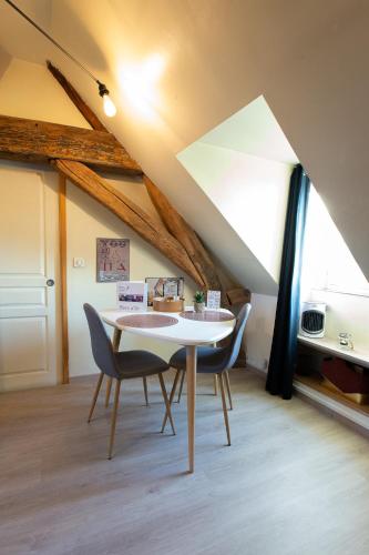 - une salle à manger mansardée avec une table et des chaises dans l'établissement Loveappart21 Pimentez votre vie de couple, à Dijon