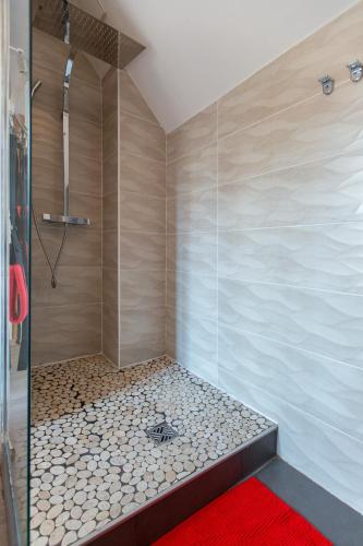 La salle de bains est pourvue d'une douche et d'un tapis rouge. dans l'établissement Loveappart21 Pimentez votre vie de couple, à Dijon