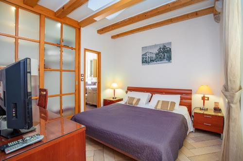 a bedroom with a bed and a television in it at Apartments Espana 1 in Dubrovnik