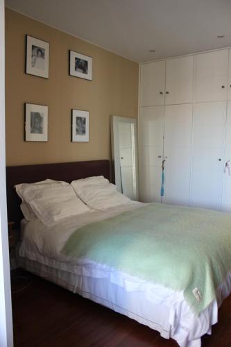 sypialnia z dużym białym łóżkiem i obrazami na ścianie w obiekcie BERNABEU, luxury y luminoso apartamento entero w Madrycie