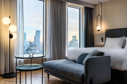 ワルシャワにあるCrowne Plaza - Warsaw - The HUB by IHGのベッド、ソファ、窓が備わるホテルルームです。