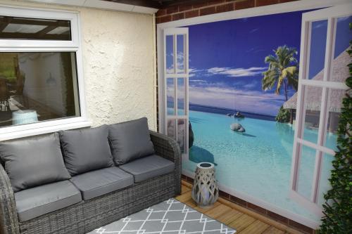 a living room with a couch and a view of the ocean at 2-Bed Cottage - Sleeps4 - Garden - Bbq in Tibshelf
