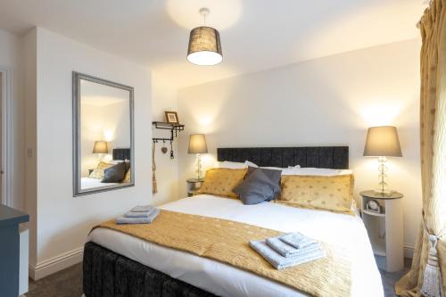 a bedroom with a large bed and a mirror at Cozy Nook a cosy 2-Bed House in Oakham Rutland in Oakham