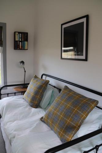 1 cama con 2 almohadas y TV en la pared en Kirkapol Beach Apartment en Middleton