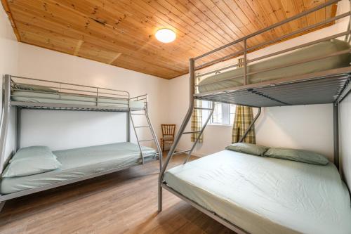 two bunk beds in a room with a wooden ceiling at Old School House -Yorkshire Dales National Park in Weathercote