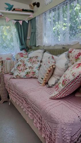 a bedroom with a bed with a pink comforter and pillows at 1 Bed Caravan Sleeps 2 - Parking Garden Pets in Lizard