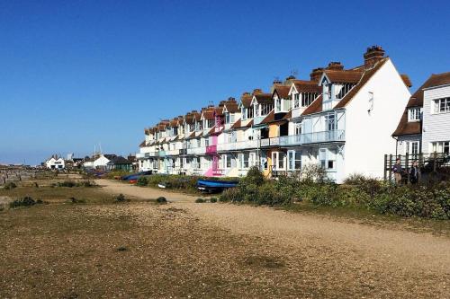 a row of houses on the side of a dirt road at Beachfront Retreat With Panoramic Views Of The Bay in Whitstable