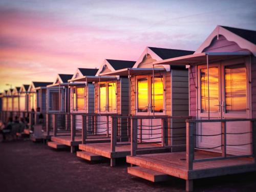 a row of houses on the beach at sunset at Cottage - Sleeps4 - PetFriendly - Garden - ByBeach in Saint Annes on the Sea