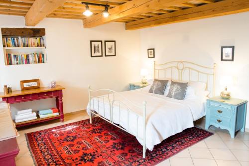 een slaapkamer met een wit bed en een rood tapijt bij Home set in olive grove with stunning views in Mondavio