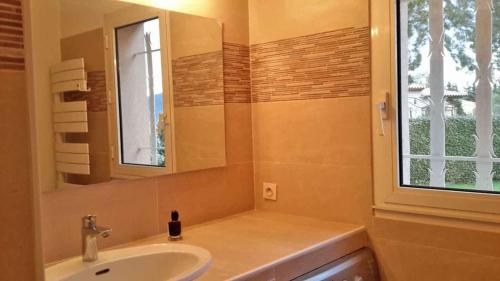 une salle de bain avec un lavabo, un miroir et une fenêtre dans l'établissement La Mastineria - private pool, à Emponse