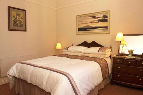 um quarto com uma cama e uma cómoda com 2 candeeiros em 4-Bed Cottage in Co Galway 5 minutes from Beach em Inverin