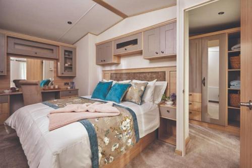 a bedroom with a large bed with blue pillows at Sherwood Lodge - South Lakeland Leisure Village in Warton