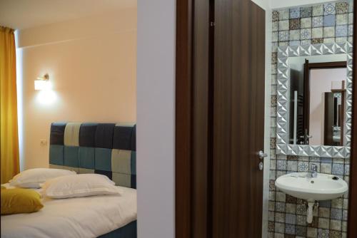 uma casa de banho com uma cama, um lavatório e um espelho. em BLISS Dubova em Dubova