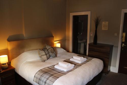 1 dormitorio con 1 cama con 2 toallas en The Royal Oak Inn en Bowness-on-Windermere