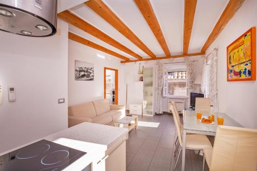 a kitchen and living room with white walls and wooden ceilings at Apartments Espana 2 in Dubrovnik