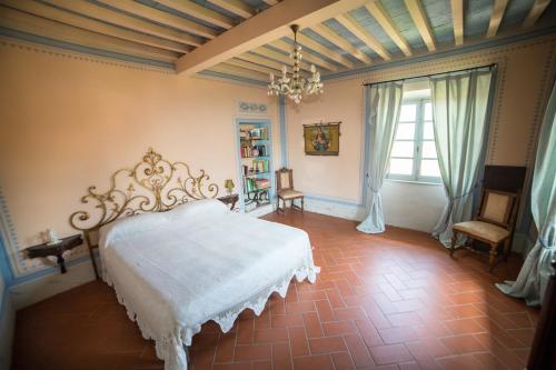 a bedroom with a white bed and a chandelier at Villa Prato-Lami in Casciana Terme