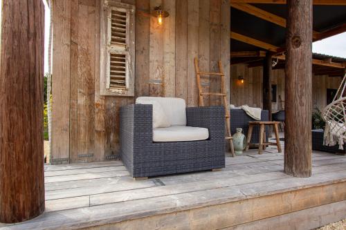a wicker chair sitting on the porch of a house at Kas Palulu II in Kralendijk