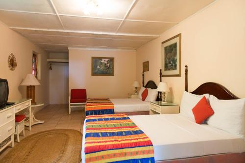 a hotel room with two beds and a tv at Villa Viento in St Mary