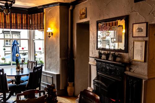 a living room with a table and a fireplace at The Royal Oak Inn in Bowness-on-Windermere