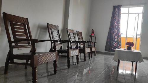 a row of chairs in a room with a table and a window at Chrisber Villa in Rajagiriya
