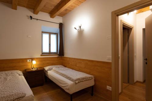 a bedroom with two beds and a window at Alla Regia in Vodo Cadore