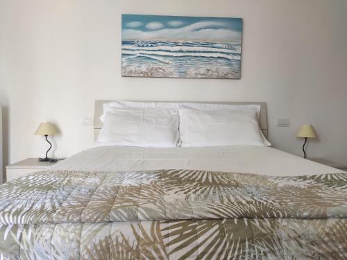 a bedroom with a bed with a painting on the wall at Sara Holiday Rentals in Bardolino