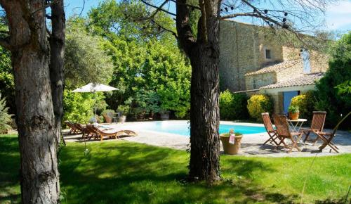 une cour avec une piscine entourée de chaises et d'un parasol dans l'établissement Mas du Clos de l'Escarrat, à Jonquières