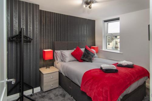 um quarto com uma cama grande e um cobertor vermelho em New Luxury Seaview Apt3 Free Parking Special Deal em Blackpool