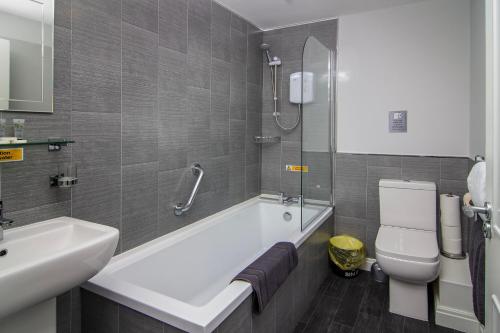 uma casa de banho com uma banheira, um WC e um lavatório. em New Luxury Seaview Apt3 Free Parking Special Deal em Blackpool