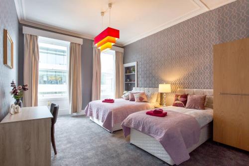 una camera d'albergo con due letti e una finestra di Stunning 2-Bed Apartment in Central Edinburgh a Edimburgo