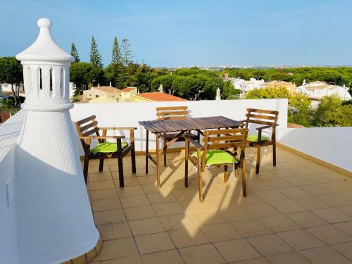 a patio with a table and chairs on a roof at Beautiful 2 Bed Apartment with views in Vilamoura in Quarteira
