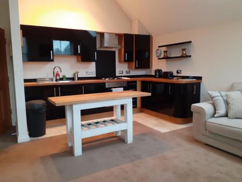 a kitchen with a table in the middle of a room at Modern 2nd floor 1 bed apartment in the heart of in Llandudno