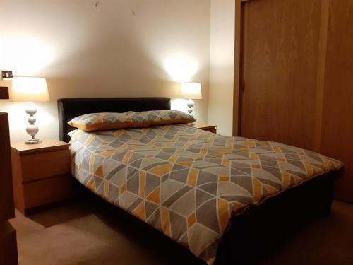 蘭迪德諾的住宿－Modern 2nd floor 1 bed apartment in the heart of，一间卧室配有一张带两张台灯的床铺。