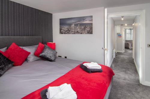 a bedroom with a bed with red and white pillows at New Luxury Seaview Apt2 Free Parking Special Deal in Blackpool