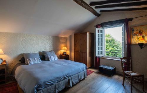 1 dormitorio con cama y ventana grande en Les pierres de Chevreuse, en Chevreuse